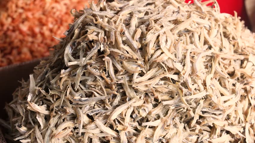 Closeup of tiny dried fish similar to anchovies used as snack or ingredient in soups popular in Asia and Europe showing texture size and food presentation