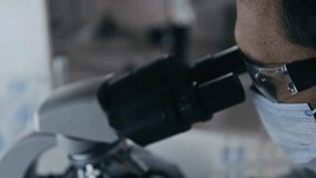 Side extreme close-up of a male scientist wearing protective goggles and a face mask, focusing on lab work in a sterile environment. - Powered by Shutterstock - Get 15% off with code: PIKWIZARD15