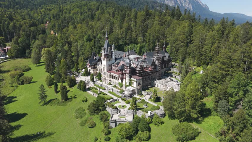 Aerial view of Peleș Castle set in a lush forest, highlighting its location within the Carpathian landscape.