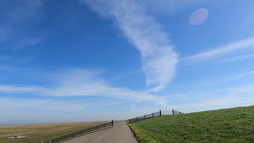 Cycling on the sea dyke through Friesland on a sunny autumn winter day