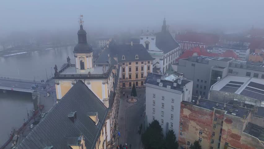 Wroclaw University baroque complex with courtyard, winter drone view in fog overlooking the Oder River surroundings