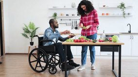 A diverse couple prepares a meal together in a modern kitchen. One person is in a wheelchair. - Powered by Shutterstock - Get 15% off with code: PIKWIZARD15