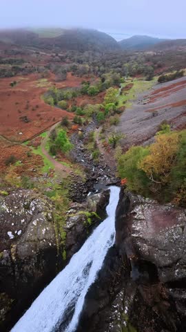 Dramatic High Angle Drone View of a Majestic Waterfall Plunging into a Mountain Valley