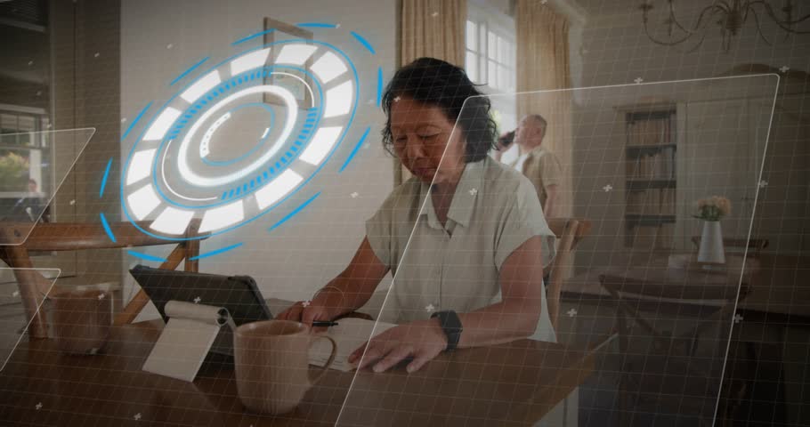 Adult man working, writing, tapping tablet, causing tech code overlay; woman arriving, calling cell. Hud, holographic, interface, dining, home, focus, window