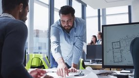 Standing man pointing and adjusting plans for review, causing alerts drifting across design studio. Collaboration, office, blueprint, floorplan, monitor, teamwork, professionals - Powered by Shutterstock - Get 15% off with code: PIKWIZARD15
