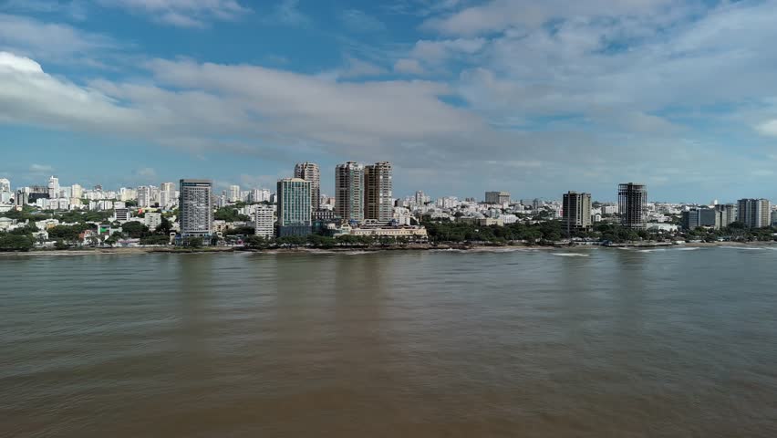Santo Domingo skyline from the Caribbean Sea. High-rise buildings and the Malecón waterfront characterize the Dominican Republic capital. Aerial drone view