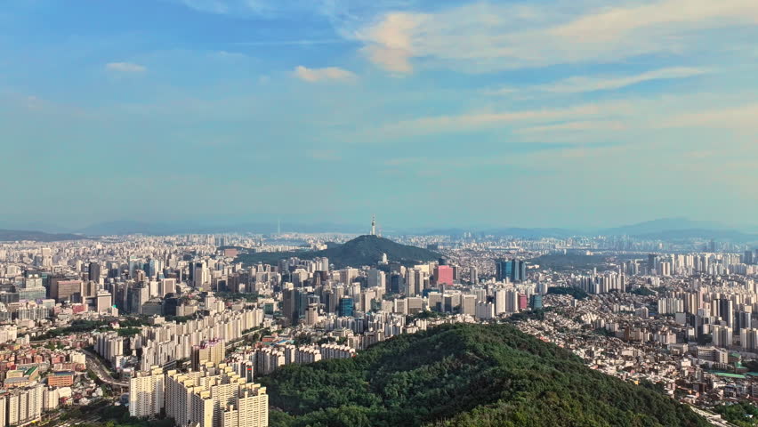 Vast Aerial View Of Seoul Cityscape In South Korea, Showcasing Namsan Tower And Modern Urban Development Under A Clear Blue Sky.