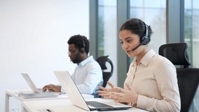 Two corporate operators working in customer support service on helpline telesale using laptop. Team of call center agents in headsets, men and women helping online, answer questions sitting in office - Powered by Shutterstock - Get 15% off with code: PIKWIZARD15