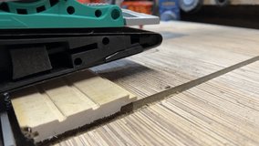 Sanding wooden board with belt sander smoothing surface texture during woodworking process creating fine dust and linear finish close up, taken handheld. High quality 4k footage - Powered by Shutterstock - Get 15% off with code: PIKWIZARD15