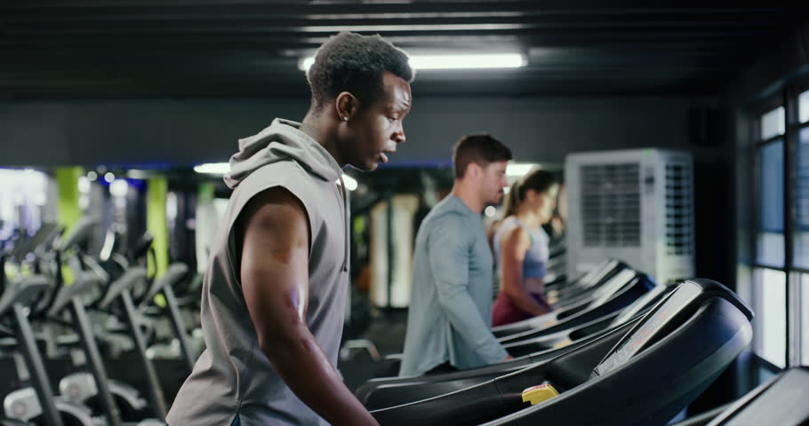 Tired, treadmill and man in gym, fitness and exercise with training, sweating and challenge. Athlete, machine and healthy person in wellness center, fatigue and endurance with workout and progress