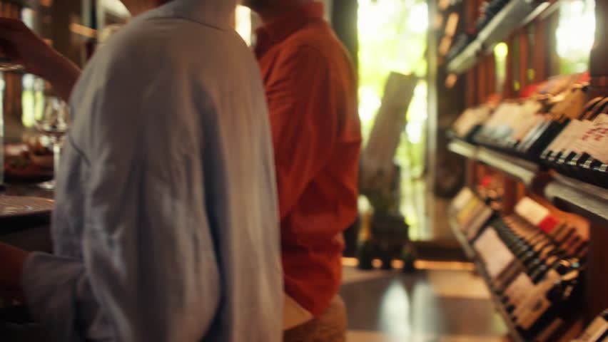 Friends raise glasses in a celebratory toast before savoring rich red wine in a luxury private cellar. Captures joy, friendship, and the experience of wine appreciation in an intimate social setting.