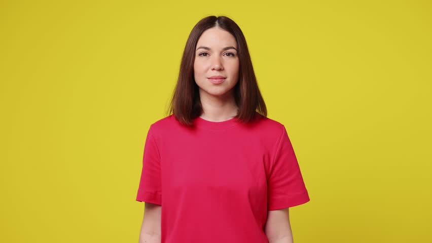 Young woman wear pink t-shirt casual clothes look camera surprised ask what wow omg no way do winner gesture say yes celebrate put hands on face isolated on plain yellow background. Lifestyle concept