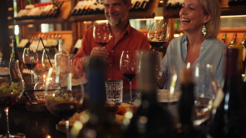 A happy couple enjoys a delightful private wine tasting experience, savoring premium red wine in an elegant cellar. They laugh, share, and appreciate the luxurious setting and exquisite flavors.