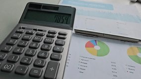 Detailed analysis of financial statistics using calculator and pie charts for effective planning - Powered by Shutterstock - Get 15% off with code: PIKWIZARD15