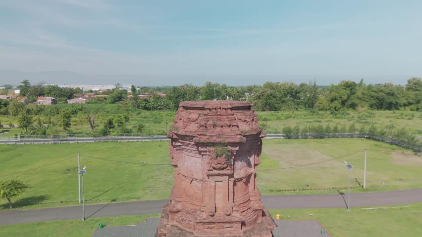 Majestic Aerial View of Historical Tower Surrounded by Lush Greenery and Scenic Landscape