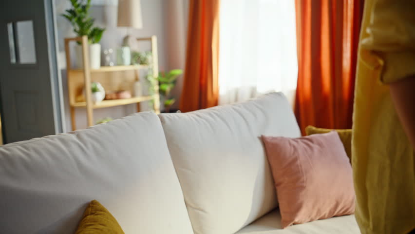 Woman sit down comfortable couch feeling tired after long day closeup. Calm brunette touching curly hair relaxing on comfortable sofa living room. Exhausted lady chilling in modern apartment alone.