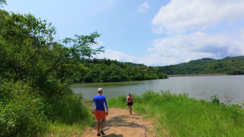 Two hikers walking near El Carrizo reservoir (Presa El Carrizo) under cloudy spring sky