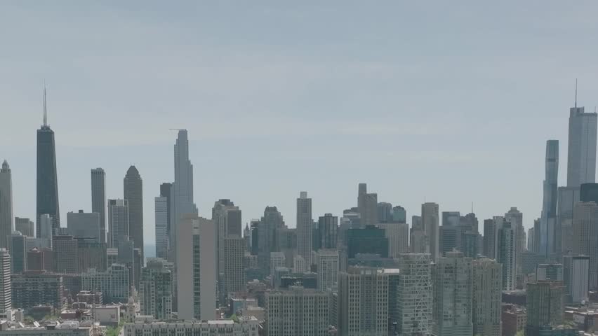 This aerial shot reveals the stunning skyline of Chicago, showcasing its diverse skyscrapers and modern architecture under a clear sky during the daytime.