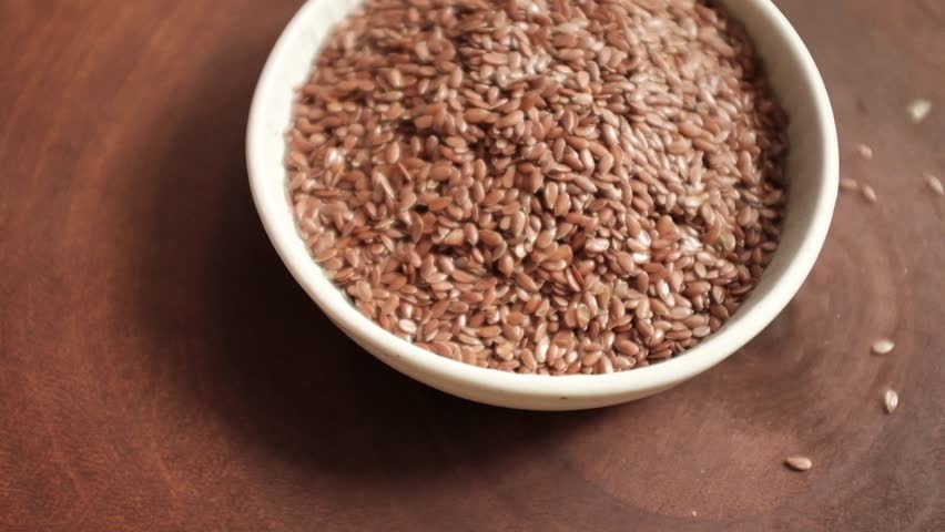 Closeup video of flax seeds in a bowl. Raw flax seeds rotating in a bowl. Superfood highly rich in fibre and omega 3 fat acid.