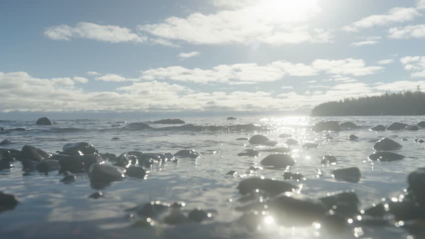Close Up of Waves Receding and Flowing Over Flat Dark Basalt Rock Shelf