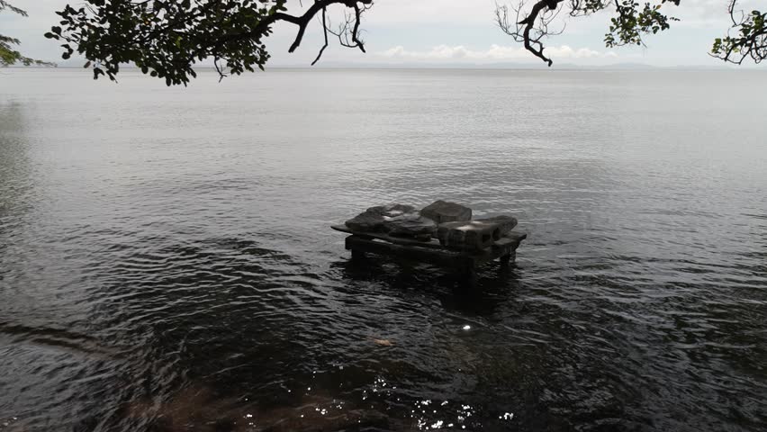 Women wash clothes on stones piled near the shore of Lake Nicaragua, showcasing a traditional activity in Central America.
