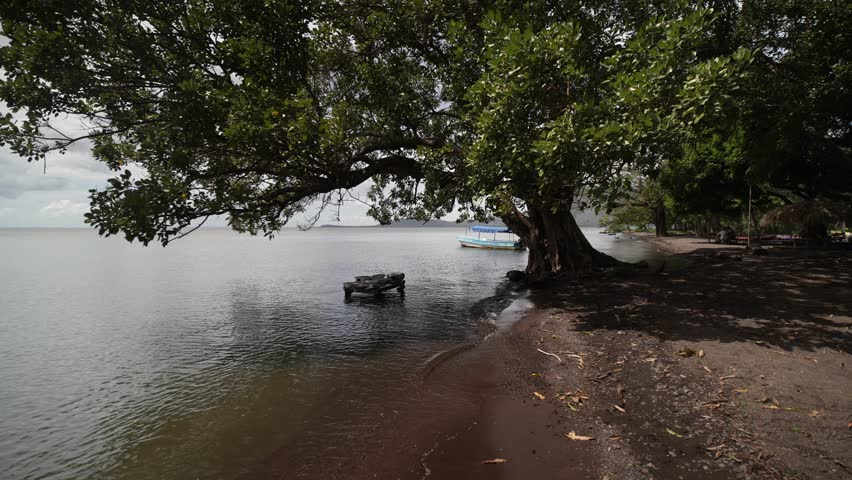 Stones near the shore of Lake Nicaragua are used by women to wash clothes while enjoying the serene natural beauty of the area.
