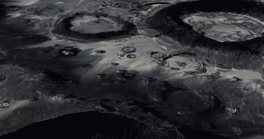 Numerous craters dot the lunar landscape, illuminated by faint light, revealing the rugged terrain and unique geological features of the moons surface at dusk.