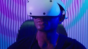 Focused cyber gamer African American man in VR helmet in dark neon futuristic space hold controllers using virtual reality software game indoor guy male cyberpunk gaming innovation futurism metaverse - Powered by Shutterstock - Get 15% off with code: PIKWIZARD15
