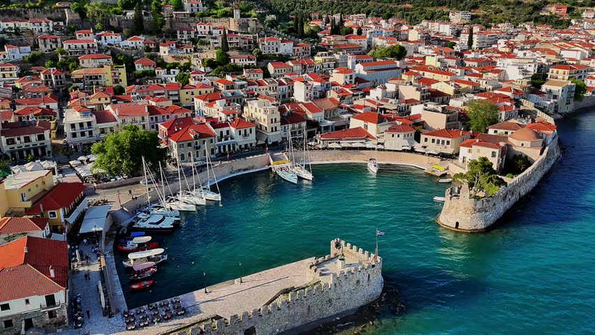 Aerial drone footage capturing the Venetian Harbour of Nafpaktos, Greece, with its iconic circular port, stone walls, and entrance towers. 