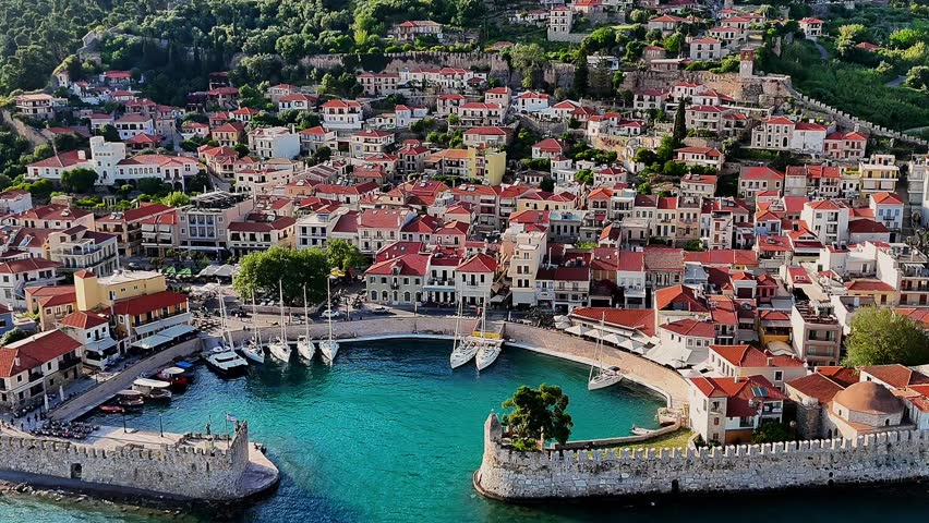 Aerial drone footage capturing the Venetian Harbour of Nafpaktos, Greece, with its iconic circular port, stone walls, and entrance towers. 