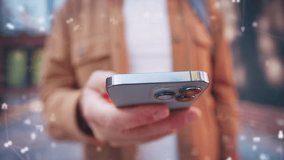 Male holding smartphone while reading message feed near modern building. Close view of hand interacting with device as digital interface elements floating around in soft outdoor environment. - Powered by Shutterstock - Get 15% off with code: PIKWIZARD15