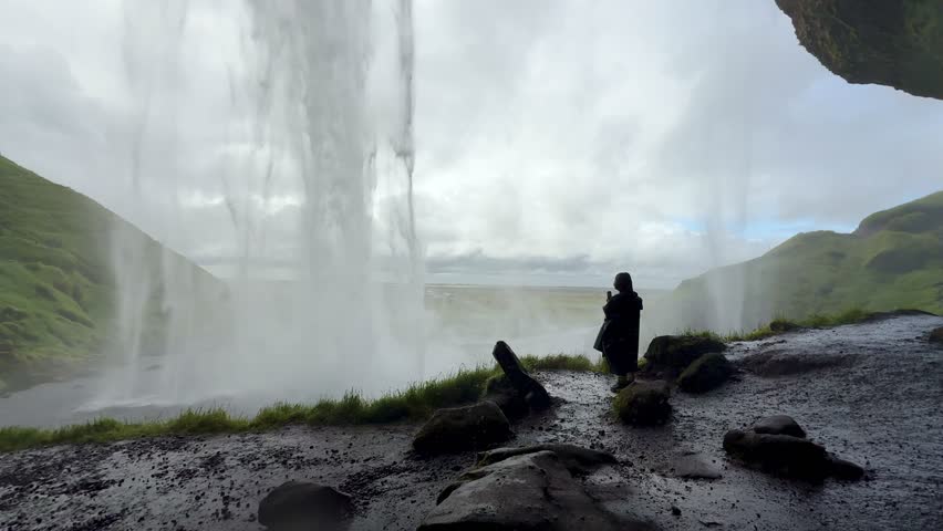 Behind the Seljalandsfoss Waterfall with Human Silhouette. High quality 4k footage