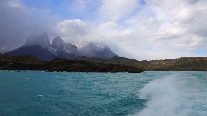 Torres del Paine mountain landscape with granite peaks, rugged terrain, dramatic skyline, Patagonia nature scenery, travel background, outdoor environment, wilderness view captured in video footage