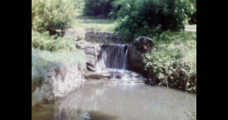 Retro Archival Footage, Water Cascade Structure Surrounded by Greenery, Manmade Waterfall and Rocky Environment