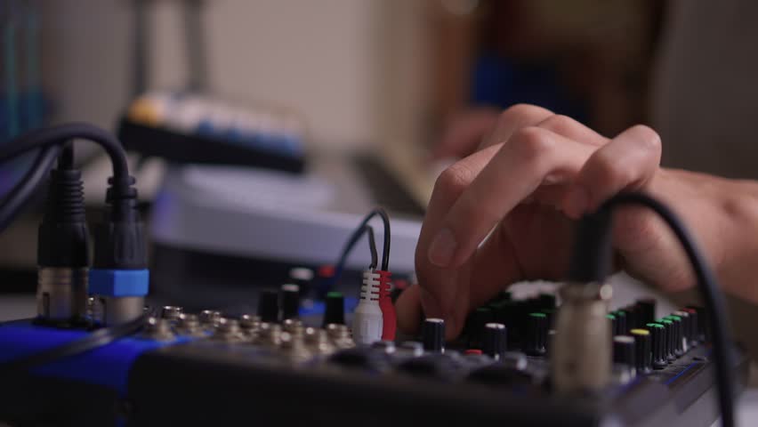 Closeup of tactile controls and vibrant patch cords in studio, Adjusting analog sequencing equipment with bright cables and warm ambient lighting in home studio