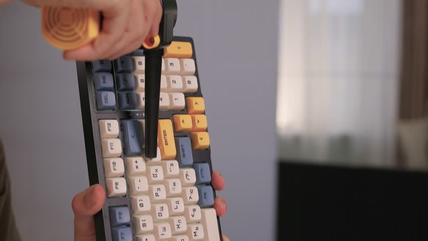 Closeup showing detailed cleaning of keyboard keys, Demonstration of meticulous keyboard cleaning involving dust removal and careful inspection in home environment