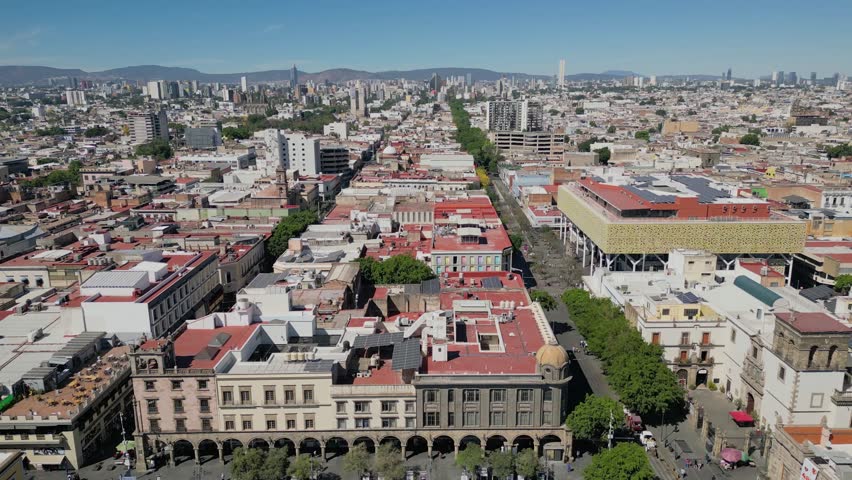 Aerial footage retreating to show Guadalajara Cathedral with Plaza Tapatia and the surrounding cityscape in view