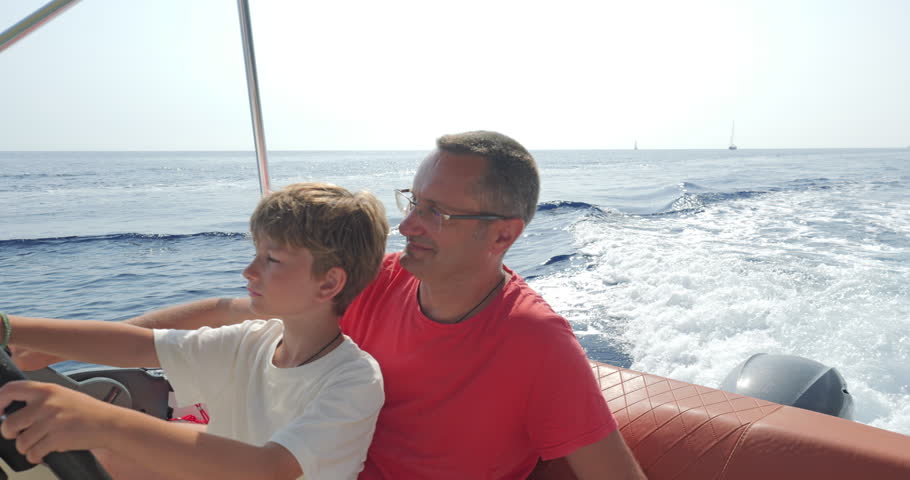 Father teaching his son how to sail a speed boat