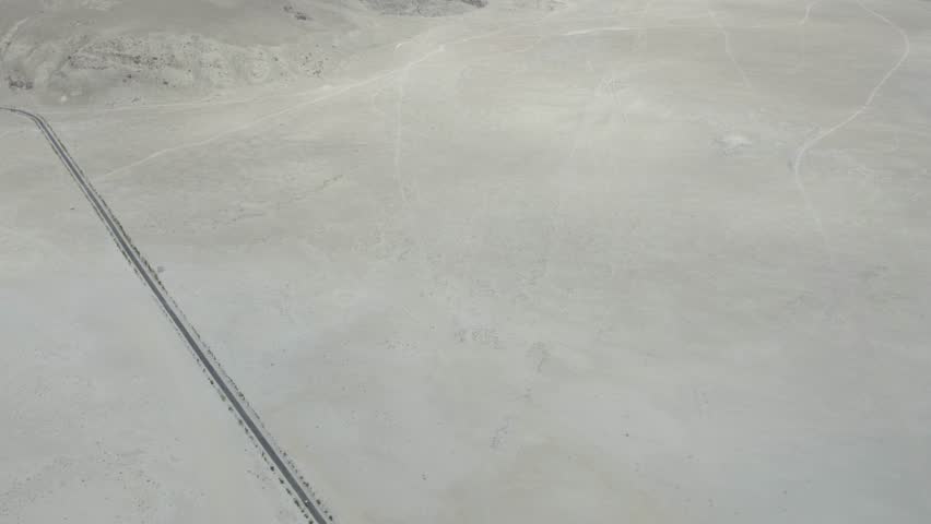 A straight road running across the pale sandy expanse of Skardu’s Cold Desert. Gilgit-Baltistan, Pakistan