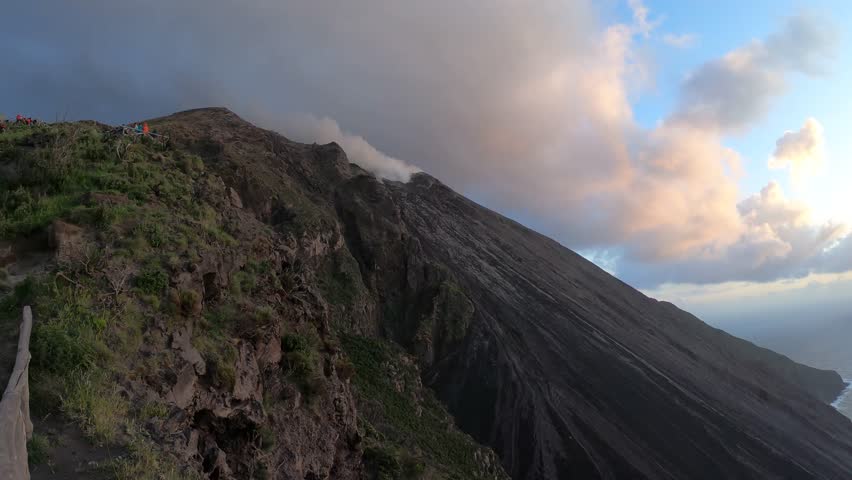 A dramatic view of the Stromboli volcano emitting smoke in the Aeolian Islands, capturing its ongoing volcanic activity and striking Mediterranean landscape.