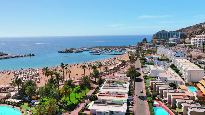 Puerto Rico de Gran Canaria, Canary Islands, Spain: Aerial view of tourist resort, Playa de Puerto Rico beach, summer day with clear blue sky - landscape panorama of Atlantic Ocean islands from above