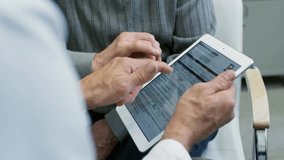 Tilt-up of a male doctor in a lab coat showing medical documents on a tablet to a senior patient. Healthcare consultation, patient education, and modern medical technology captured. - Powered by Shutterstock - Get 15% off with code: PIKWIZARD15
