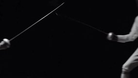 Slow-motion of two fencers competing in foil fighting inside a dark studio. Dynamic sports action, precision, and agility captured in a dramatic, cinematic environment. - Powered by Shutterstock - Get 15% off with code: PIKWIZARD15