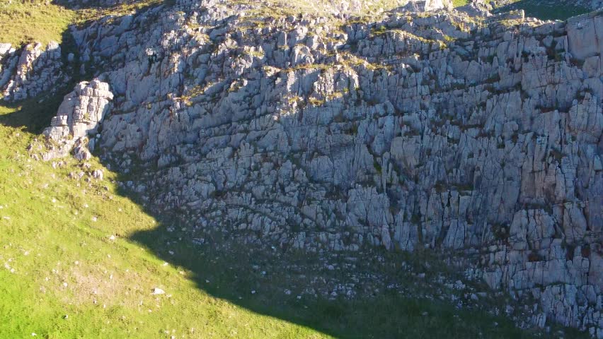 Parallax Rising Aerial Reveal of South Wales Coast Path with Stone Wall with Eroding Cliffs and Livestock Fields. Travel Nature Drone Clip.