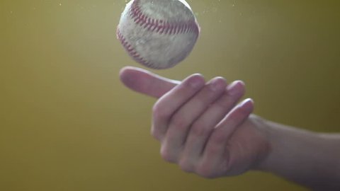 Tossing baseball in hand slow motion with lots of flare. 