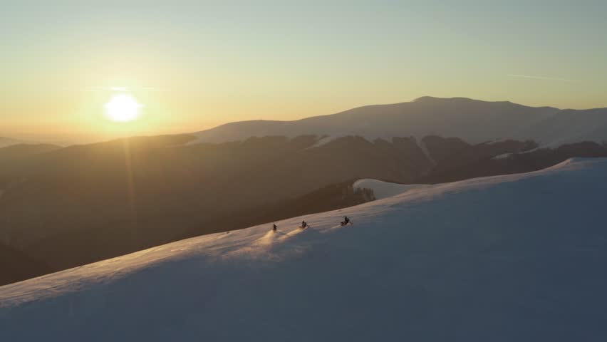 Aerial view of snow track motorbikes carving through untouched winter landscape