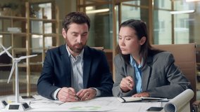 Multiracial business team discussing wind turbine project sustainable investment eco energy Korean woman investor windmill Caucasian businessman environmental strategy innovation partnership office - Powered by Shutterstock - Get 15% off with code: PIKWIZARD15