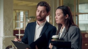 Multiethnic Korean businesswoman Caucasian business man manager discuss project holding coffee cup clipboard paperwork pointing finger gesture talk writing teamwork cooperation report analysis office - Powered by Shutterstock - Get 15% off with code: PIKWIZARD15