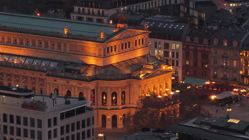 Stunning aerial footage shot with a tripod from a unique place of Alte Oper concert hall in Frankfurt am Main, Germany, glowing warmly against city buildings