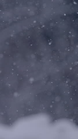 SUPER SLOW MOTION, CLOSE UP, DOF: Mesmerizing view of slowly falling snowflakes that gently cover nature in cold winter season. Heavy snowfall causing poor visibility and snowdrifts in wintertime.